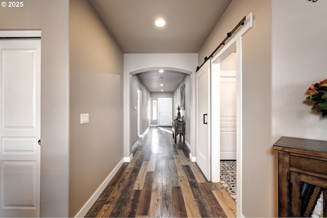 hallway featuring dark hardwood / wood-style floors and a barn door