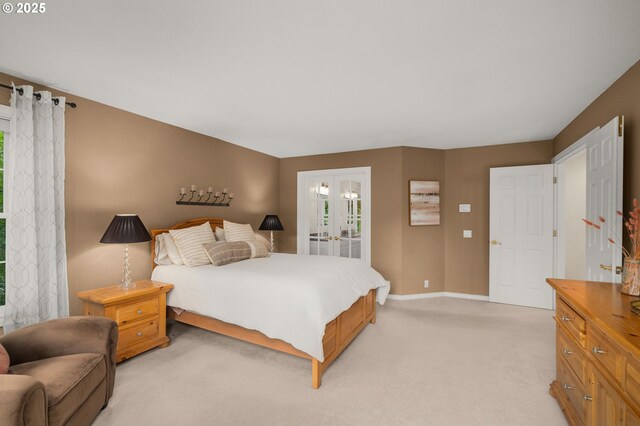 4503 NW 147th Ave, Portland, OR 97229 - bedroom with french doors, baseboards, light colored carpet, and connected bathroom