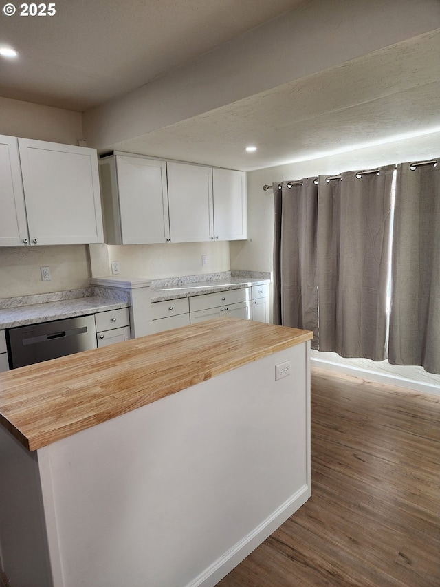 kitchen featuring stainless steel dishwasher, wooden counters, white cabinets, and dark wood-style flooring