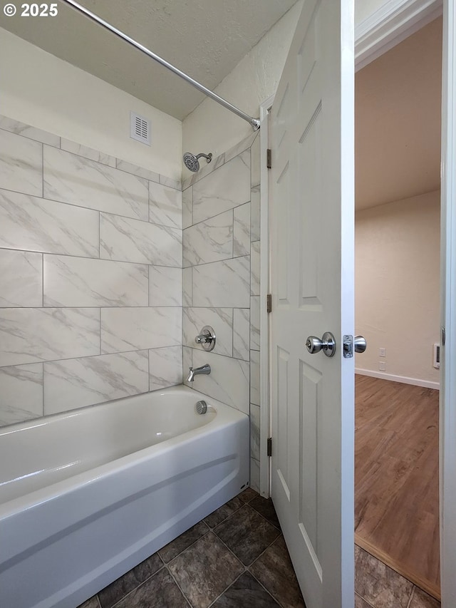 full bathroom featuring baseboards, visible vents, and bathing tub / shower combination