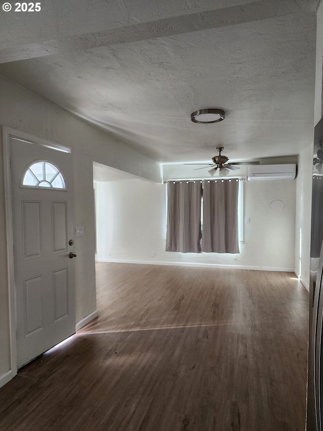 foyer entrance with ceiling fan, a textured ceiling, baseboards, a wall mounted AC, and dark wood-style floors