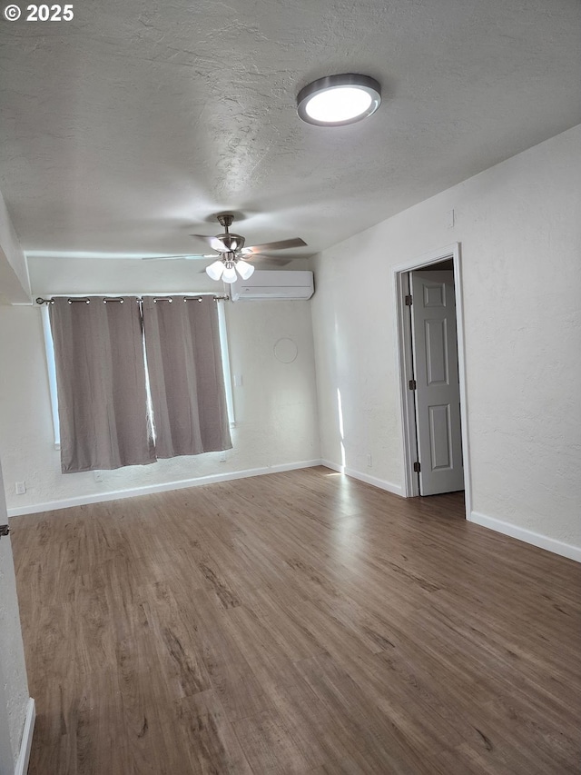 empty room featuring dark wood-style floors, a textured ceiling, baseboards, and a ceiling fan