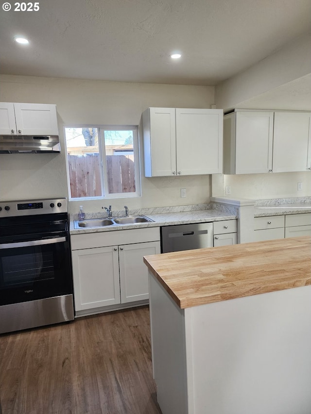 kitchen with under cabinet range hood, white cabinetry, wood counters, and appliances with stainless steel finishes