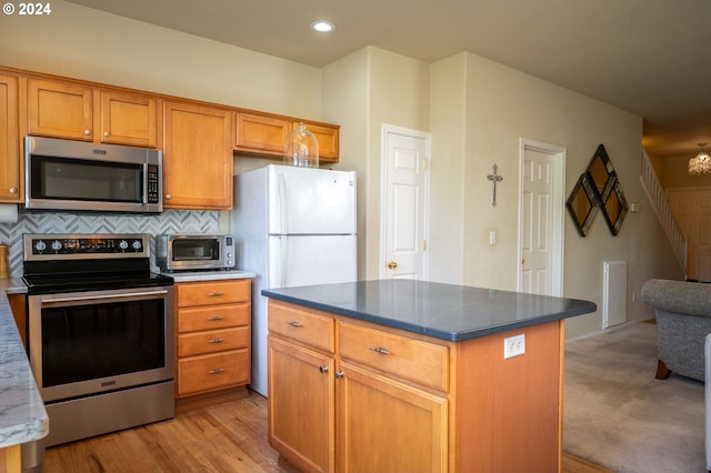 kitchen featuring a center island, light hardwood / wood-style floors, appliances with stainless steel finishes, and tasteful backsplash