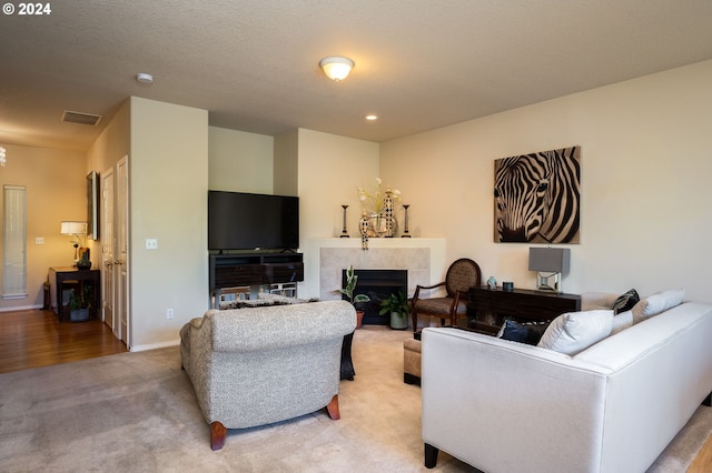 living room featuring light colored carpet and a tile fireplace