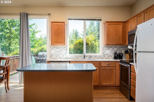 kitchen with a center island, a healthy amount of sunlight, stainless steel appliances, and tasteful backsplash