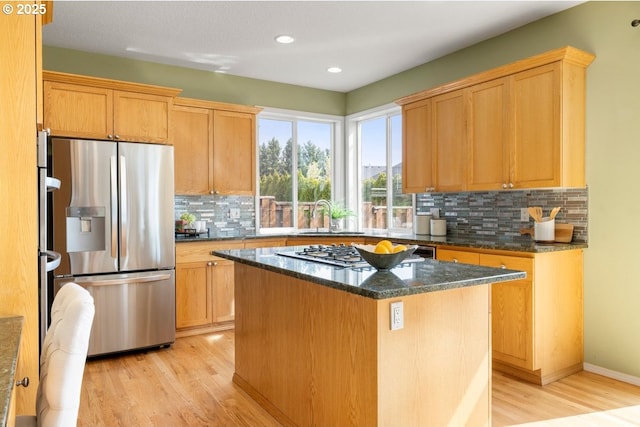3816 NW Tustin Ranch Dr, Portland, OR 97229 - kitchen featuring stainless steel appliances, light wood-style floors, a sink, a kitchen island, and tasteful backsplash