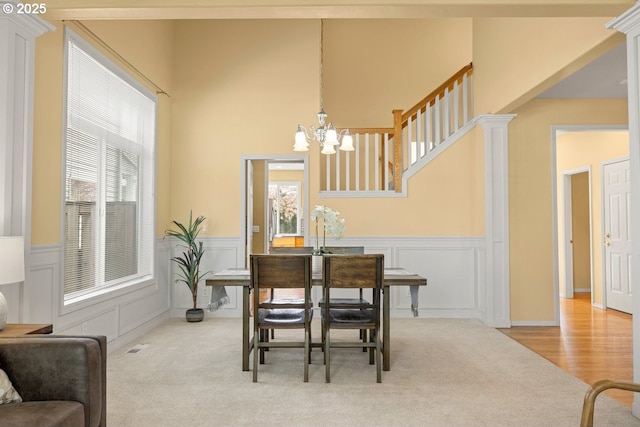 3816 NW Tustin Ranch Dr, Portland, OR 97229 - carpeted dining room with plenty of natural light, a chandelier, a decorative wall, and a wainscoted wall