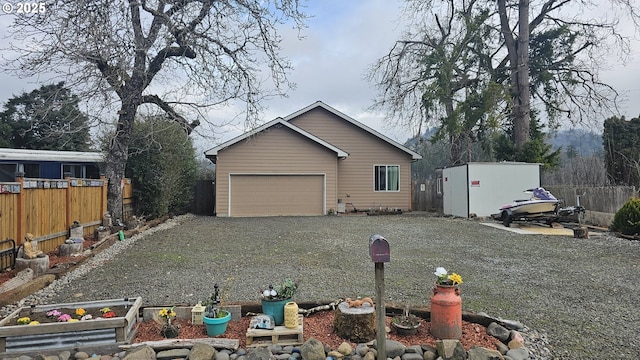 exterior space featuring gravel driveway, an outbuilding, and fence