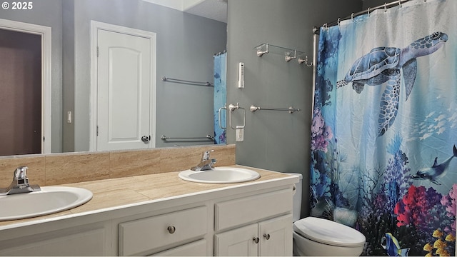 bathroom with double vanity, toilet, and a sink