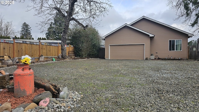 exterior space featuring fence, a garage, and driveway