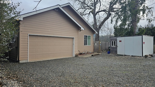 view of property exterior with a detached garage and an outbuilding