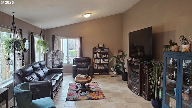 living room featuring lofted ceiling, baseboards, and a textured ceiling