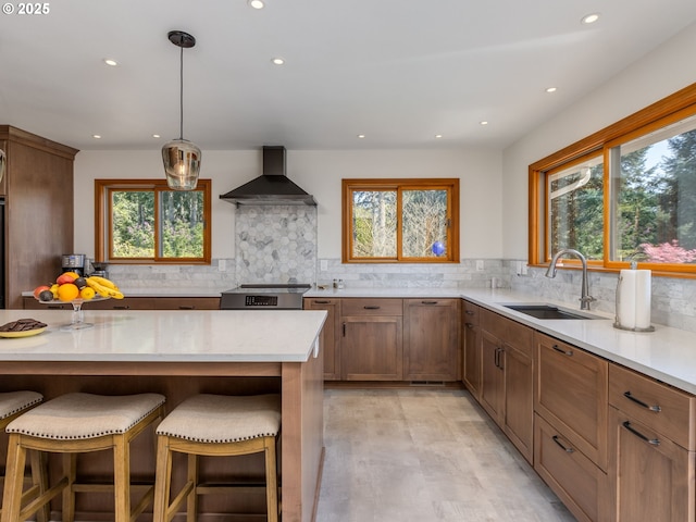 12720 S Carus Rd, Oregon City, OR 97045 - kitchen with wall chimney range hood, a sink, a breakfast bar area, backsplash, and recessed lighting