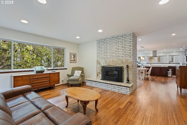 living room with hardwood / wood-style flooring and a brick fireplace