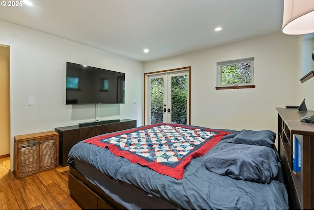 bedroom with wood-type flooring, access to outside, and french doors