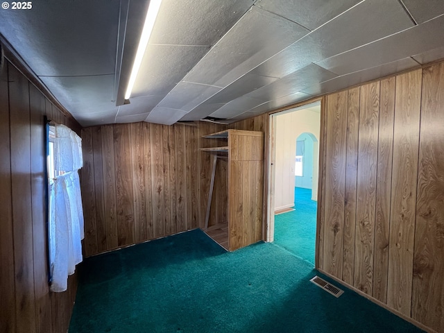 2909 College St, Baker City, OR 97814 - unfurnished bedroom featuring wood walls, carpet floors, and arched walkways