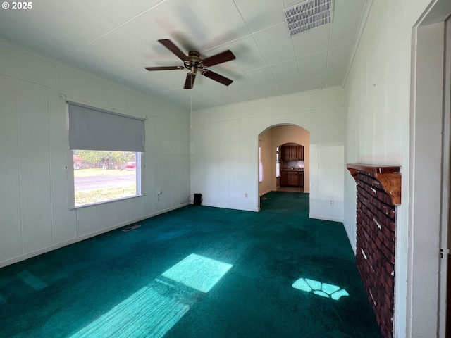 2909 College St, Baker City, OR 97814 - unfurnished living room featuring arched walkways, dark carpet, ceiling fan, and ornamental molding