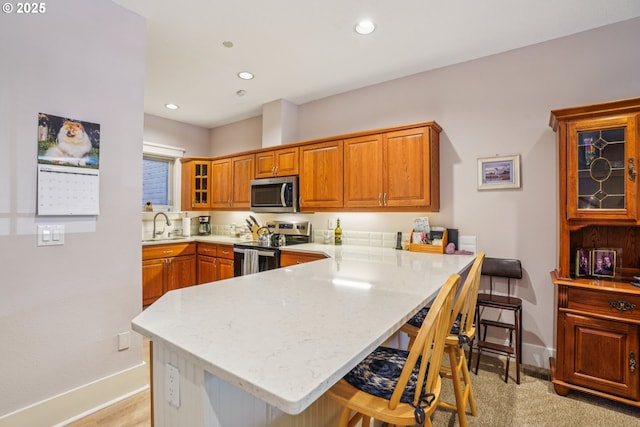 240 NE 5th St, Gresham, OR 97030 - kitchen featuring stainless steel appliances, baseboards, a breakfast bar, a peninsula, and recessed lighting