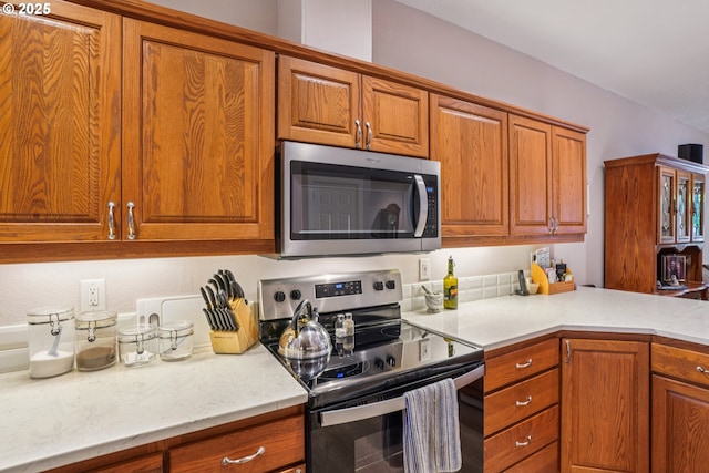 240 NE 5th St, Gresham, OR 97030 - kitchen featuring stainless steel appliances, brown cabinetry, and light countertops