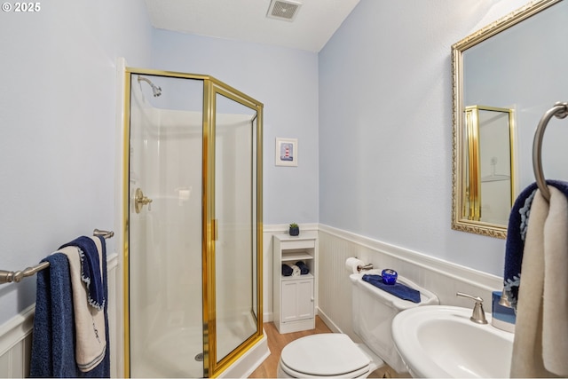 240 NE 5th St, Gresham, OR 97030 - bathroom with a sink, a shower stall, wainscoting, toilet, and wood finished floors