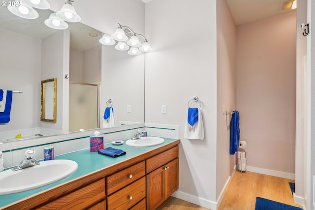 240 NE 5th St, Gresham, OR 97030 - full bathroom with a shower stall, double vanity, wood finished floors, baseboards, and backsplash