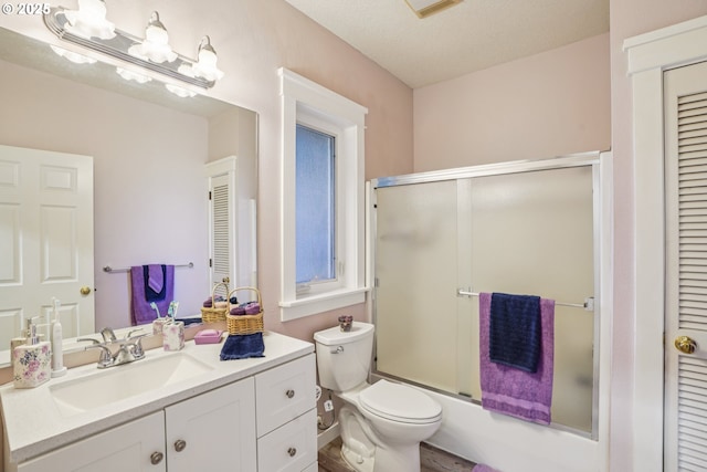 240 NE 5th St, Gresham, OR 97030 - bathroom with vanity, a closet, toilet, and bath / shower combo with glass door