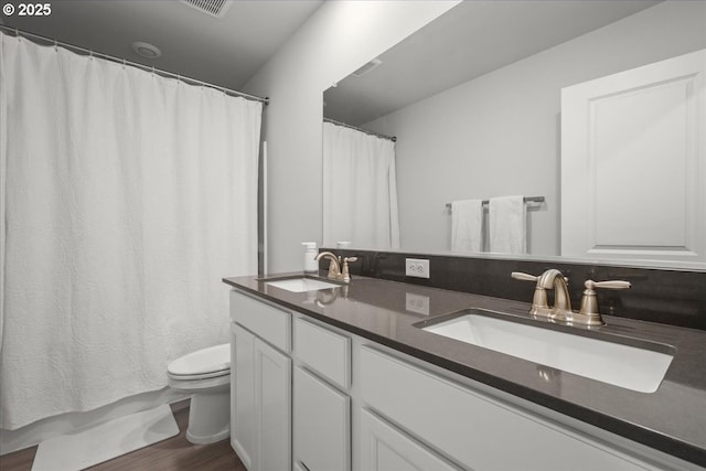 bathroom with hardwood / wood-style flooring, curtained shower, toilet, and vanity