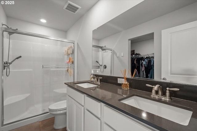 bathroom with walk in shower, vanity, and toilet