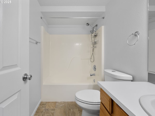 full bathroom featuring toilet, bathing tub / shower combination, stone finish floor, and vanity