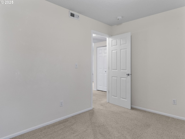 unfurnished room with visible vents, carpet flooring, and baseboards