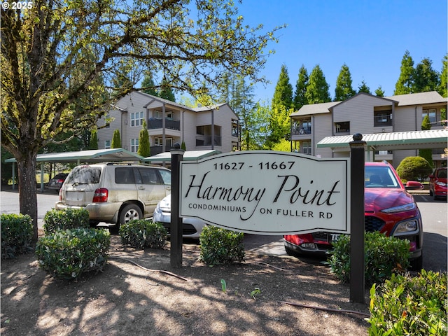 community / neighborhood sign featuring uncovered parking