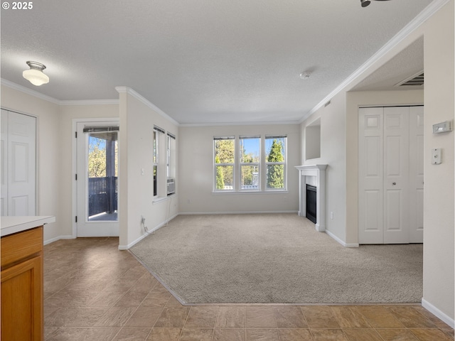 unfurnished living room with light carpet, a fireplace, a textured ceiling, baseboards, and ornamental molding