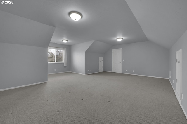 bonus room with vaulted ceiling and carpet