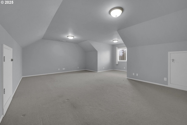 additional living space featuring lofted ceiling and carpet floors