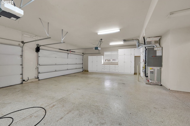 garage featuring heating unit and a garage door opener