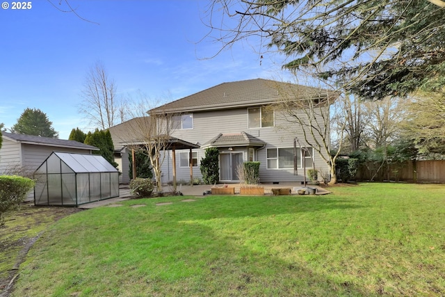 back of property featuring a yard and an outbuilding