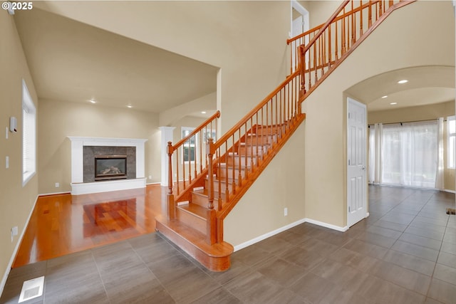 stairway with a fireplace and tile patterned flooring