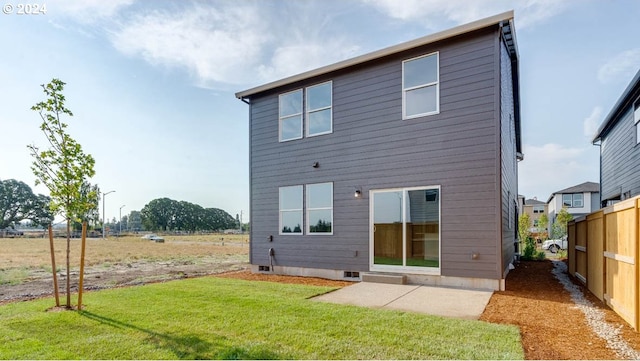 rear view of property featuring a yard and a patio