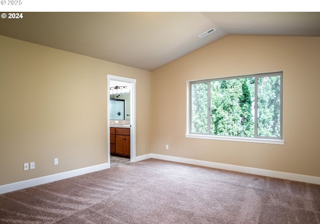 carpeted spare room featuring lofted ceiling