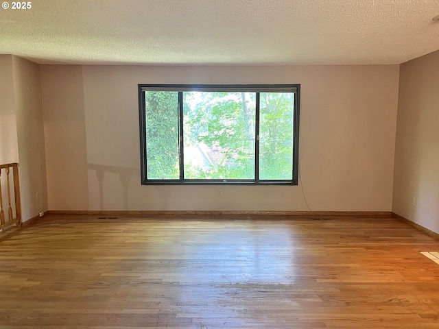 16042 Cornell St, Lake Oswego, OR 97034 - empty room featuring plenty of natural light, wood finished floors, and a textured ceiling