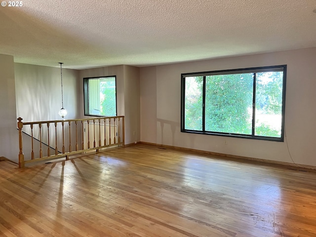 16042 Cornell St, Lake Oswego, OR 97034 - spare room with healthy amount of natural light, a textured ceiling, and wood finished floors