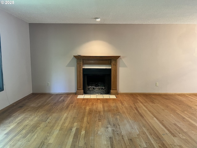 16042 Cornell St, Lake Oswego, OR 97034 - unfurnished living room featuring wood finished floors, a textured ceiling, and a fireplace