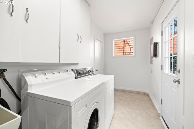 clothes washing area with cabinet space, a sink, washer and clothes dryer, and baseboards