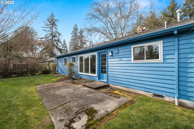 back of house featuring a patio area and a lawn