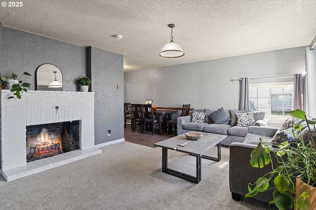 carpeted living room featuring a brick fireplace, a textured wall, a textured ceiling, and baseboards