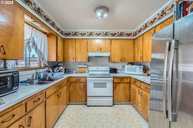 6135 SE Clatsop St, Portland, OR 97206 - kitchen featuring stainless steel appliances, under cabinet range hood, light countertops, brown cabinets, and light floors