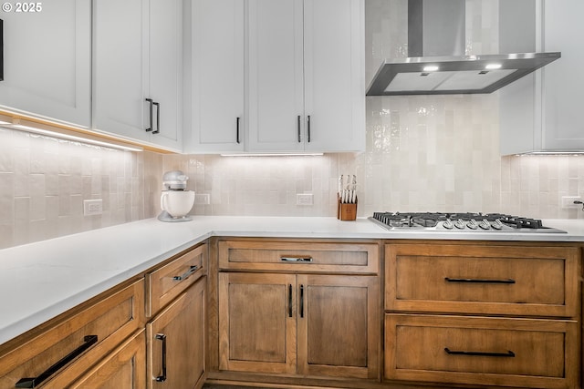 kitchen featuring tasteful backsplash, stainless steel gas stovetop, and wall chimney exhaust hood