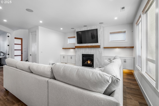 living room with dark hardwood / wood-style floors and a large fireplace