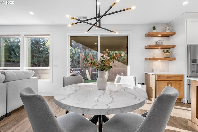 dining area featuring a notable chandelier and light hardwood / wood-style floors